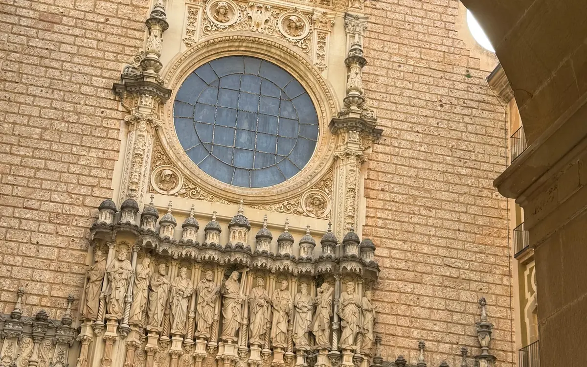Carved stone figures and a round window on the front of the basilica